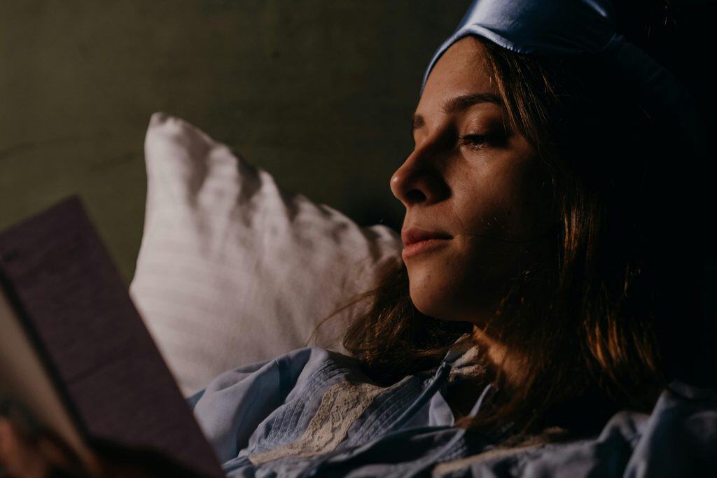 quick self care ideas - a woman lying in bed reading a book