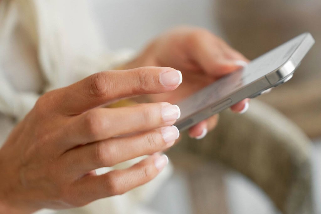 a close-up of a woman's hands holding a phone